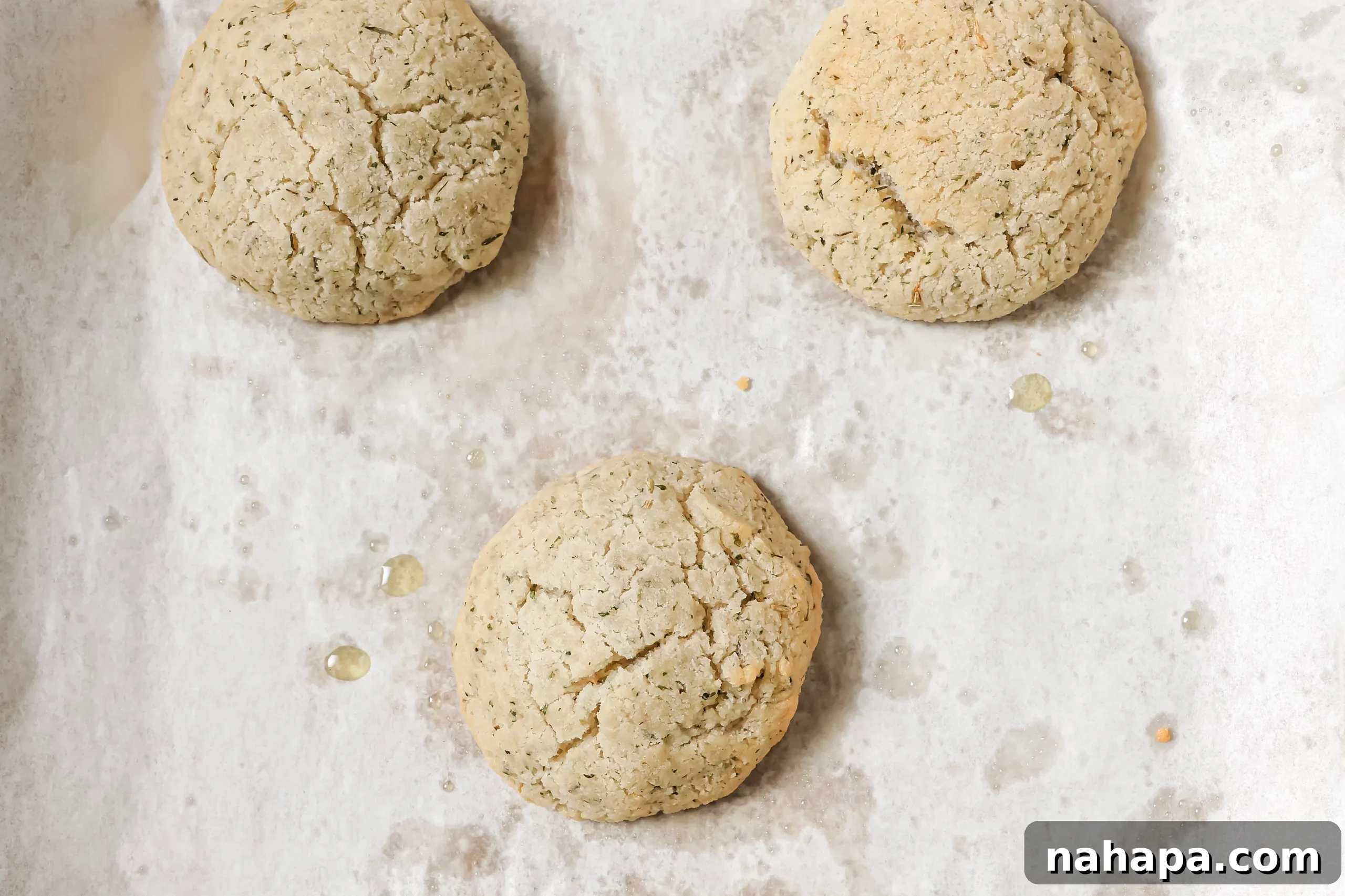 Five cooked bread rolls on a baking sheet