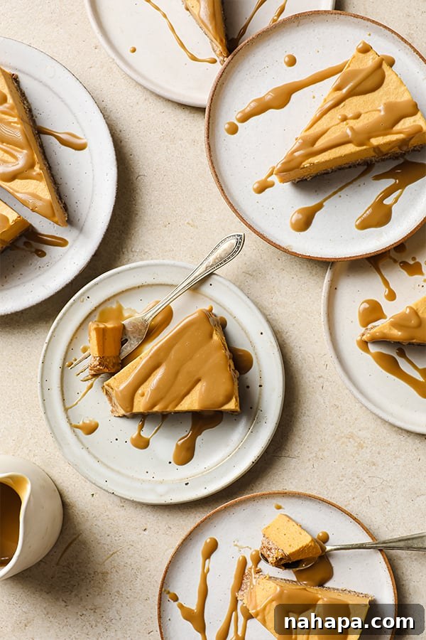 AIP Paleo Autumn Salted Caramel Pumpkin Cheesecake 8 A slice of dairy-free salted caramel pumpkin cheesecake on a white plate, topped with caramel and salt flakes, showcasing its creamy texture.