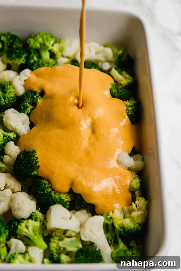 Broccoli Cheese Casserole with the dairy-free sauce poured over vegetables, ready for baking.