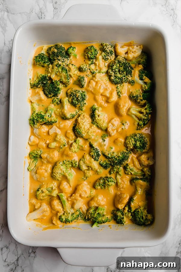 Assembled Healthy Broccoli Cheese Casserole topped with crushed plantain chips, ready for baking.