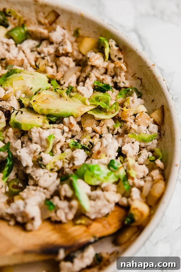 Preparing the flavorful turkey filling for acorn squash, with diced vegetables and herbs