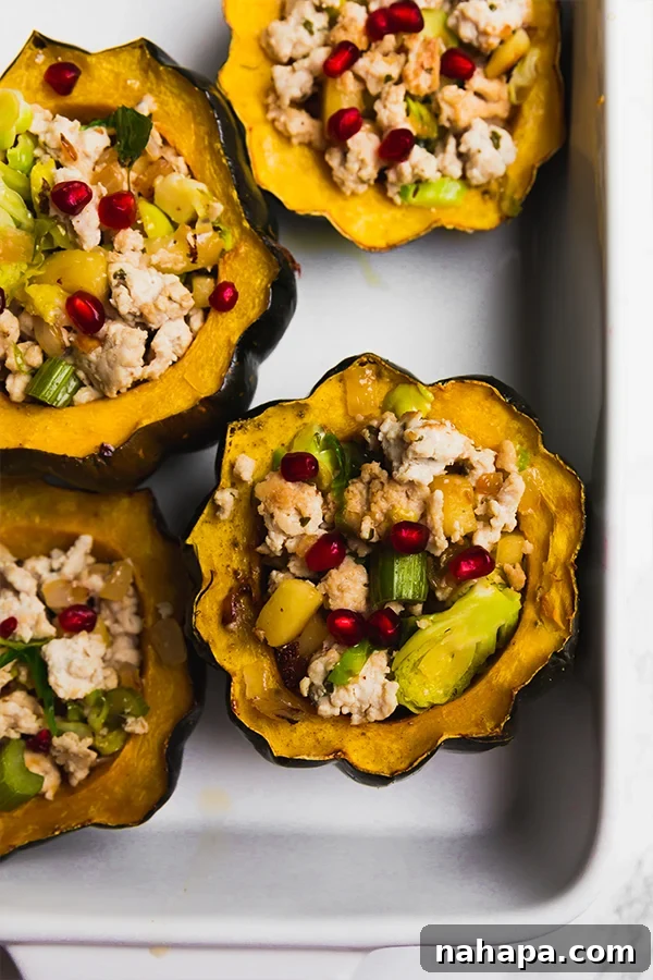 Two beautiful Turkey Stuffed Acorn Squash halves in a baking dish, ready to serve.