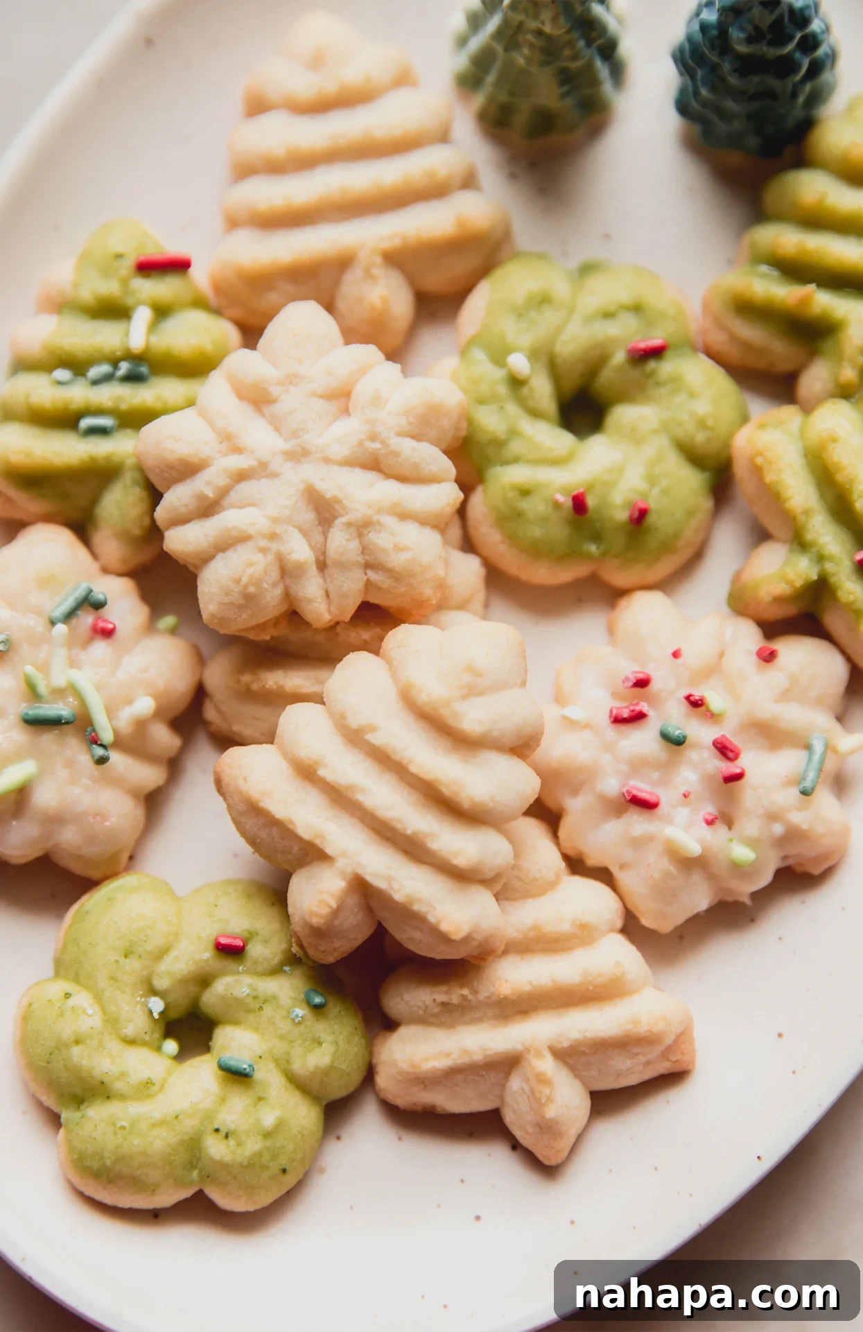 Festively shaped gluten-free spritz cookies adorned with sprinkles, arranged beautifully on a platter.