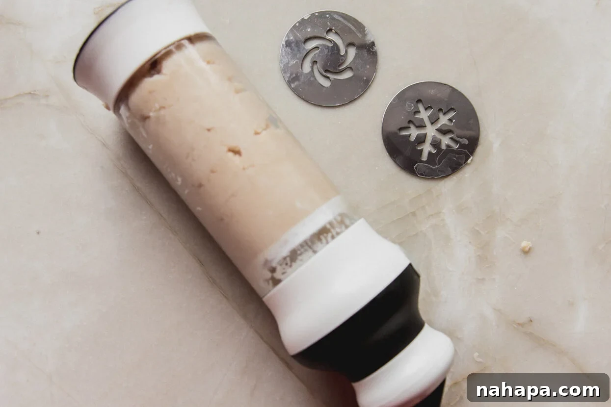 A cookie press with the prepared spritz cookie dough carefully loaded inside, ready for pressing.