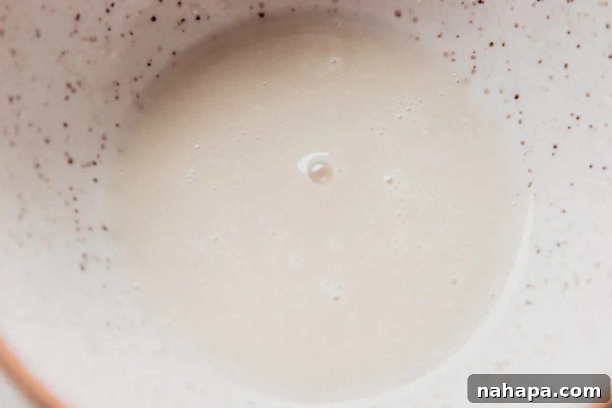 Smooth white icing for spritz cookies, prepared and ready in a bowl.