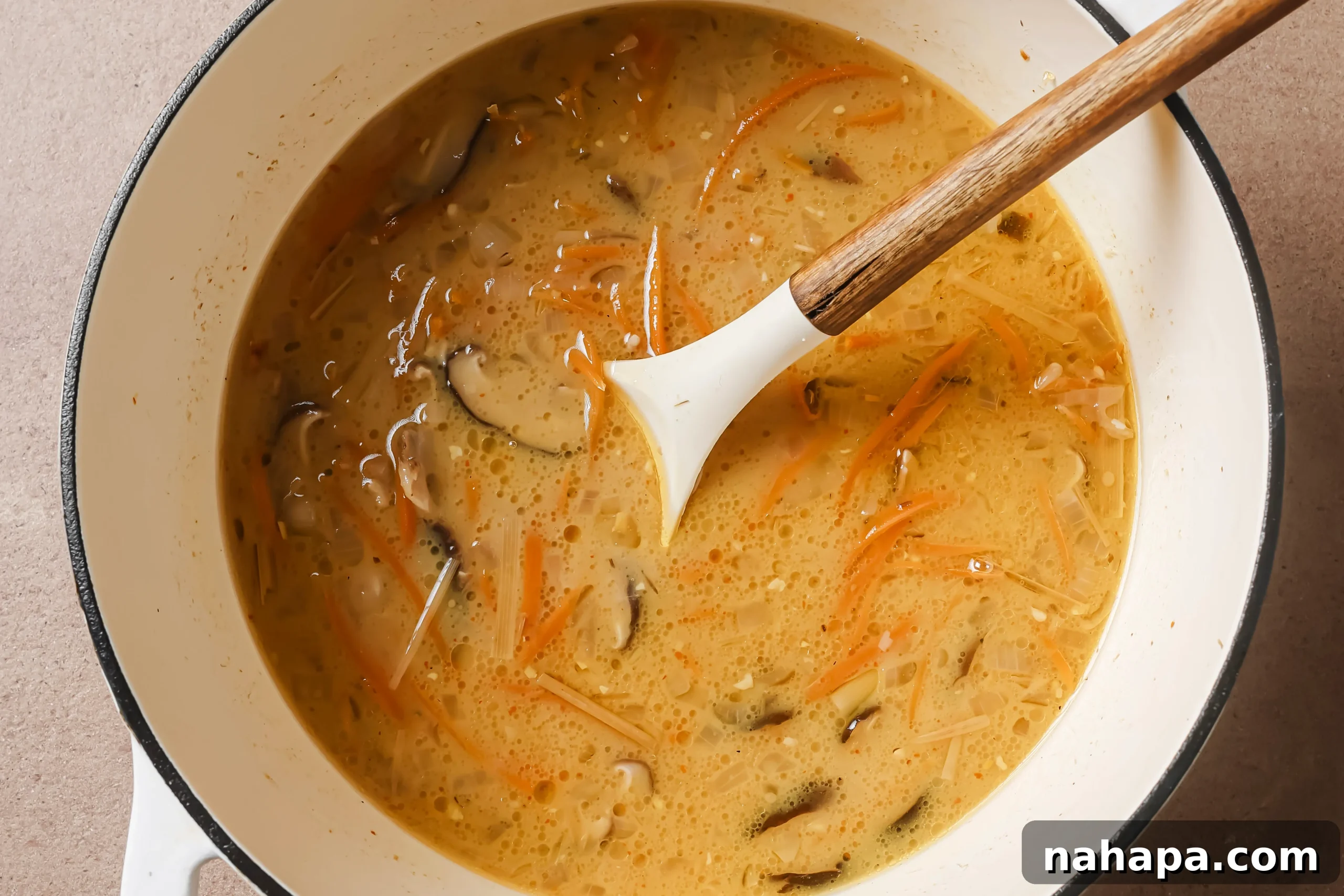 A pot of fully cooked Tom Kha soup, simmering gently, with vibrant colors and fragrant steam rising, indicating it's ready to serve.
