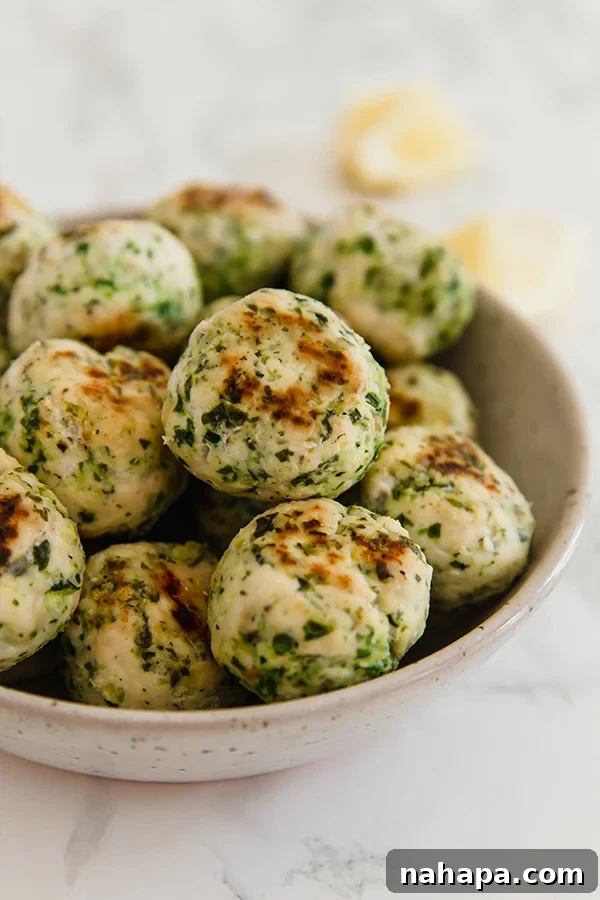 Mediterranean Harvest Chicken and Veggie Meatballs 2 Mediterranean Veggie & Chicken Meatballs served in a bowl, garnished with fresh herbs, ready to be enjoyed.