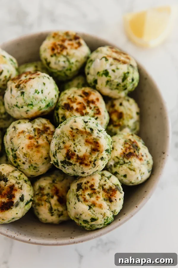 Mediterranean Harvest Chicken and Veggie Meatballs 4 Baked Mediterranean Veggie & Chicken Meatballs displayed on a platter, garnished with fresh dill, ready to serve.