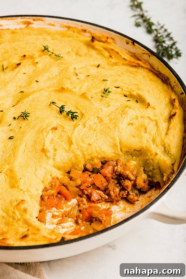 Ultimate Turkey Shepherds Bake 4 A scoop has been taken from the freshly baked turkey shepherd's pie, revealing the hearty filling beneath the mashed sweet potato topping.