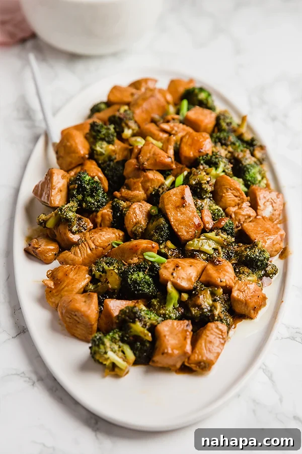 Easy 20-Minute Chicken and Broccoli Stir-Fry 4 A large cooking pan filled with chicken and broccoli stir fry, being tossed by a spatula