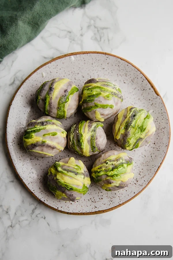 Close-up of three no-bake king cake truffles, showcasing the vibrant natural coloring and appealing texture