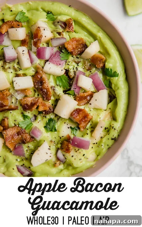 Applewood Bacon Guacamole 6 A beautifully presented bowl of Apple Bacon Guacamole with a scoop taken out, surrounded by fresh dippers.