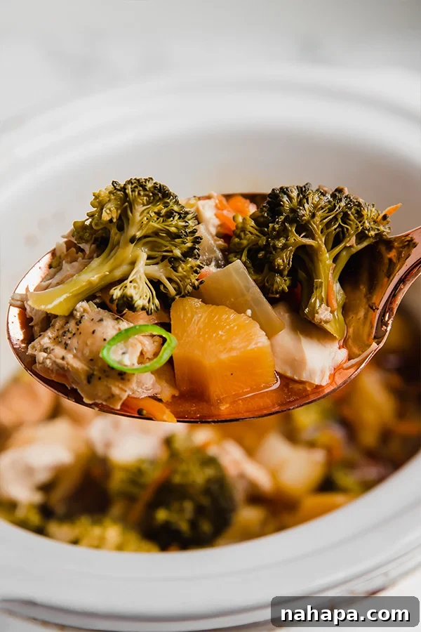 Hawaiian chicken cooking in a slow cooker, showing tender chicken pieces with pineapple and vegetables