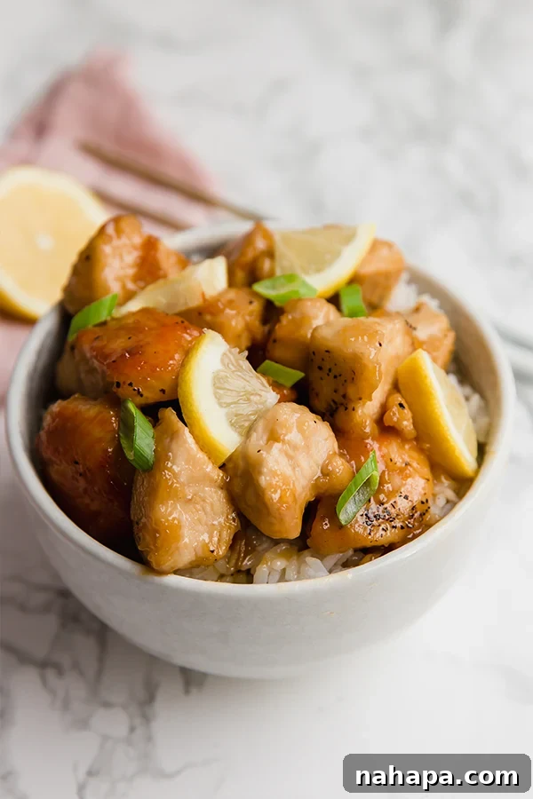 Tangy Lemon Chicken 3 Close-up of Sticky Chinese Lemon Chicken in a pan, garnished with green onions