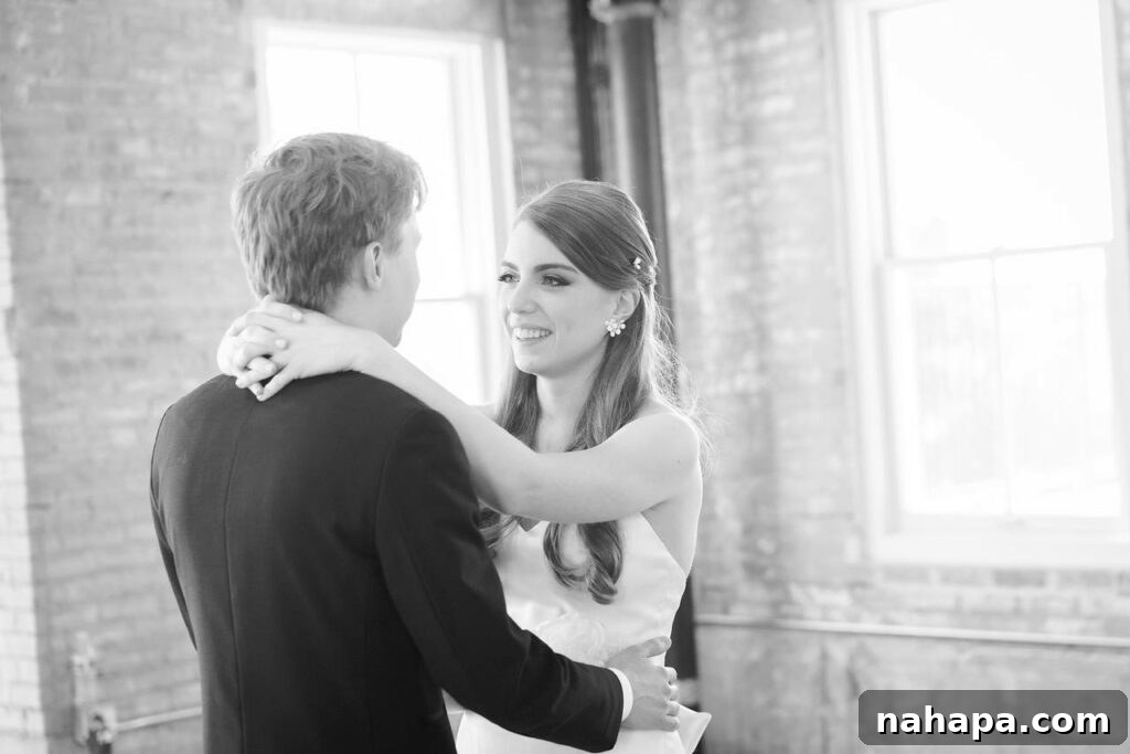 A black and white photo of a bride dancing with the groom.