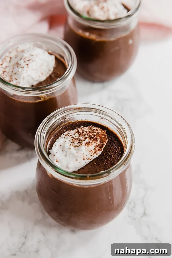 Rich homemade chocolate pudding served in a small glass jar.