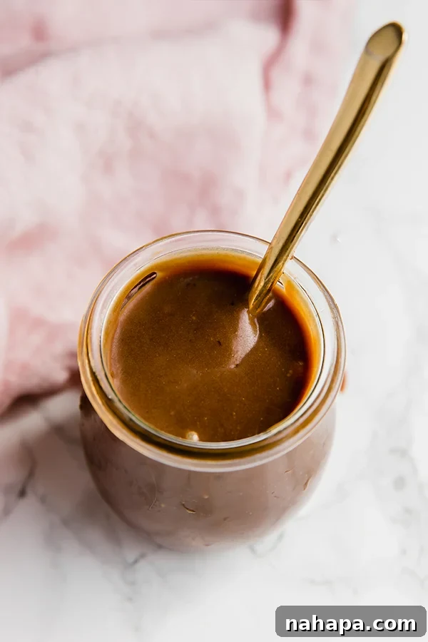 Decadent Homemade Paleo Dulce De Leche 3 A close-up of thick, golden-brown homemade Dulce de Leche, showing its rich and smooth texture.