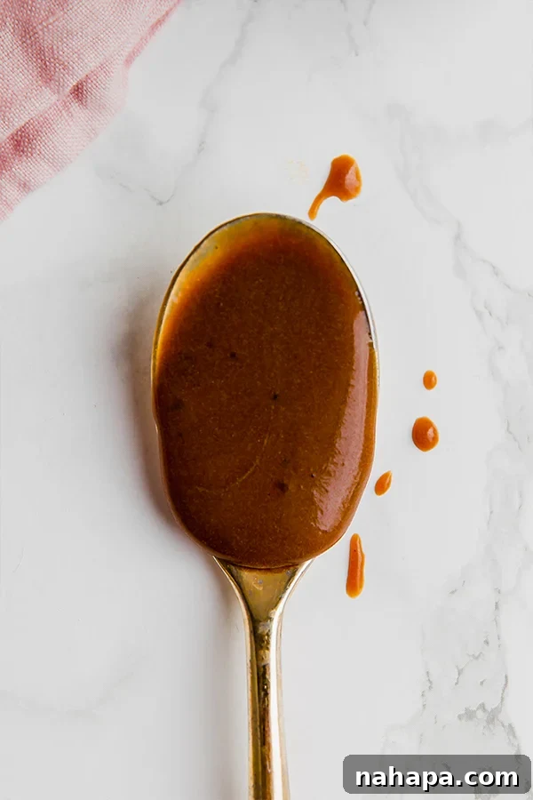 Decadent Homemade Paleo Dulce De Leche 4 A serving of Paleo Dulce de Leche artfully drizzled over fresh fruit, showcasing its versatile use as a dessert topping.