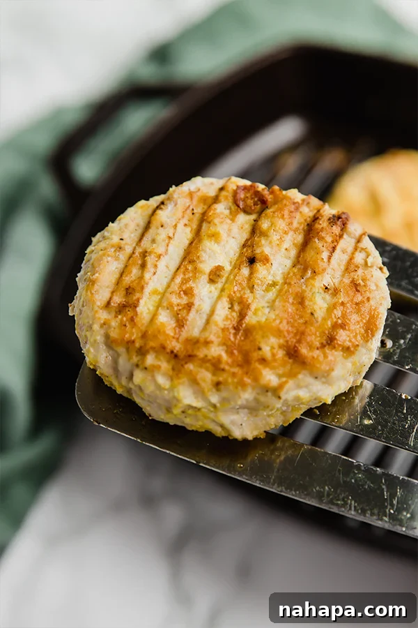 Grilled Tandoori chicken burgers on a cast iron grill pan, ready to be served.
