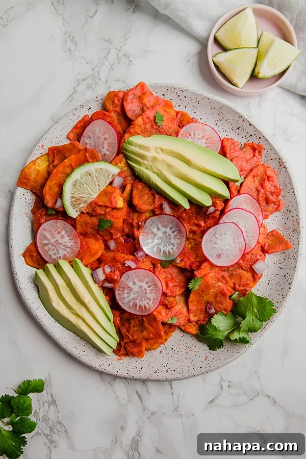 Sauce-coated plantain chips ready for chilaquiles toppings