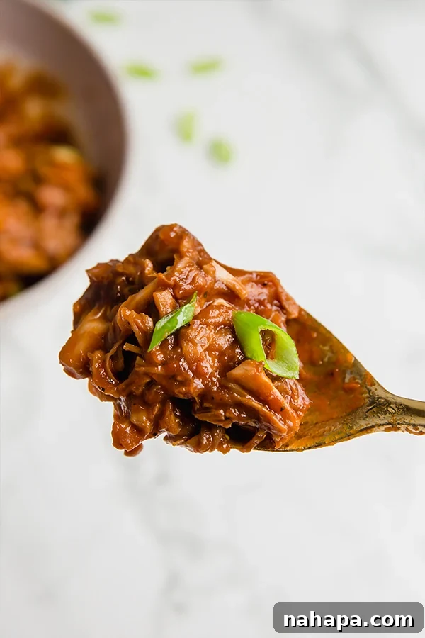 Smoky Pulled Jackfruit 5 A delicious BBQ jackfruit taco topped with fresh green onions, showcasing a creative and healthy way to serve this plant-based dish.