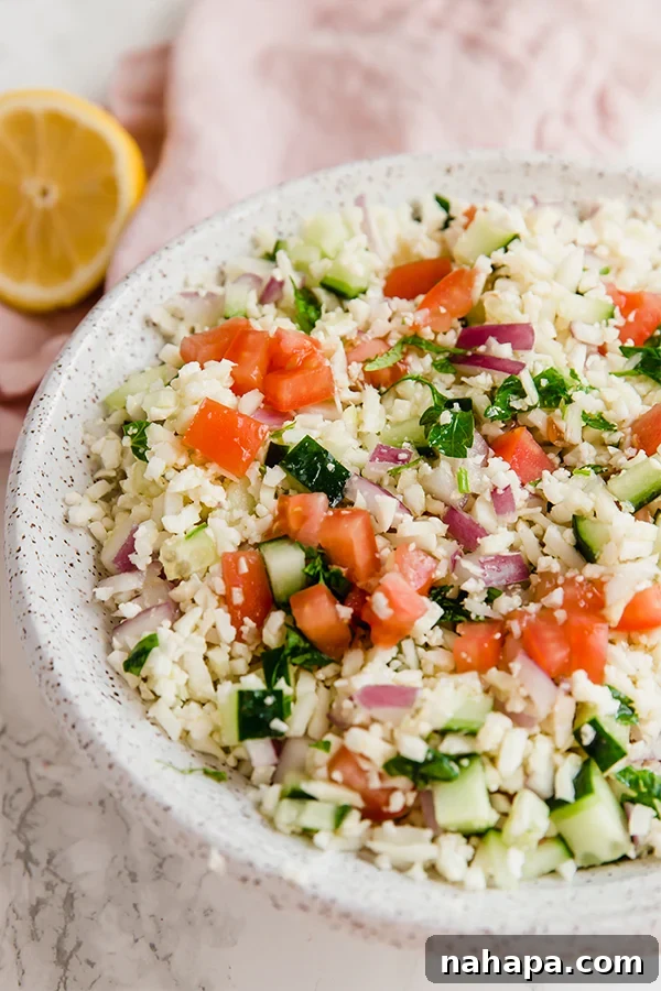 Close-up of freshly prepared cauliflower tabbouleh salad with visible herbs and vegetables.