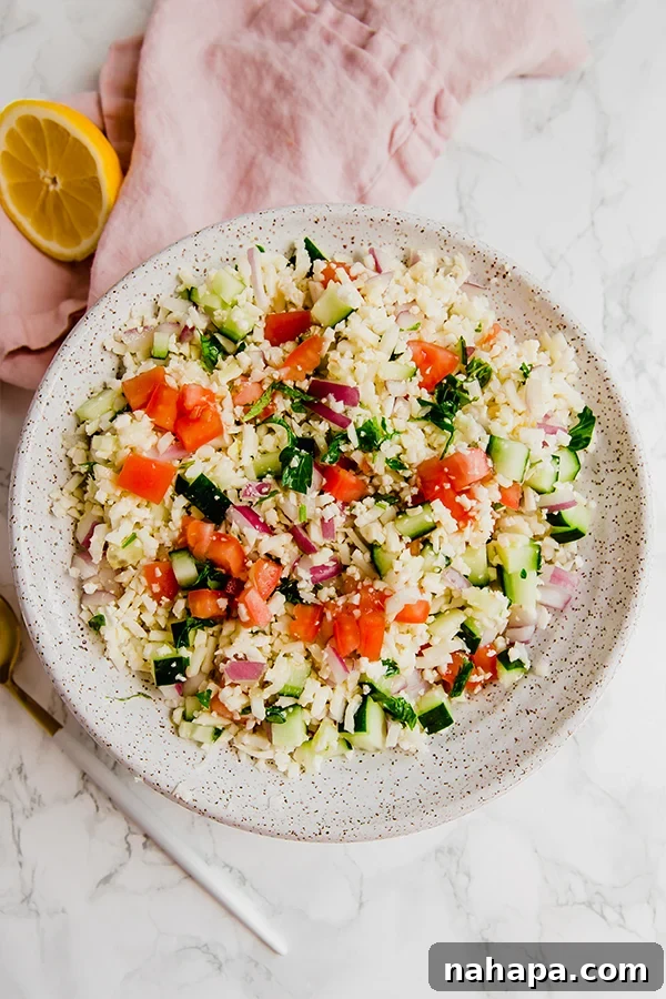 Overhead shot of a delicious cauliflower tabbouleh salad in a white bowl, ready to be served.