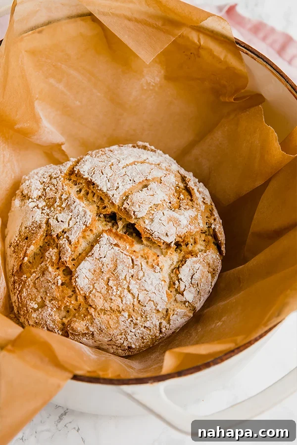 Rustic no-knead gluten-free bread loaf with garlic and herbs, sliced on a wooden board
