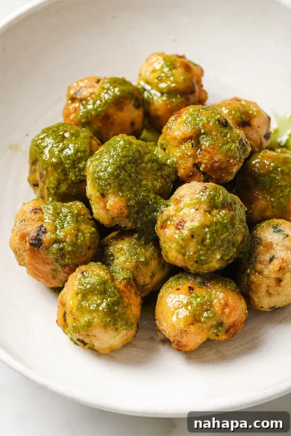 Garden Fresh Turkey Pesto Meatballs 6 Turkey Pesto Meatballs ready to be served, garnished with fresh basil leaves.