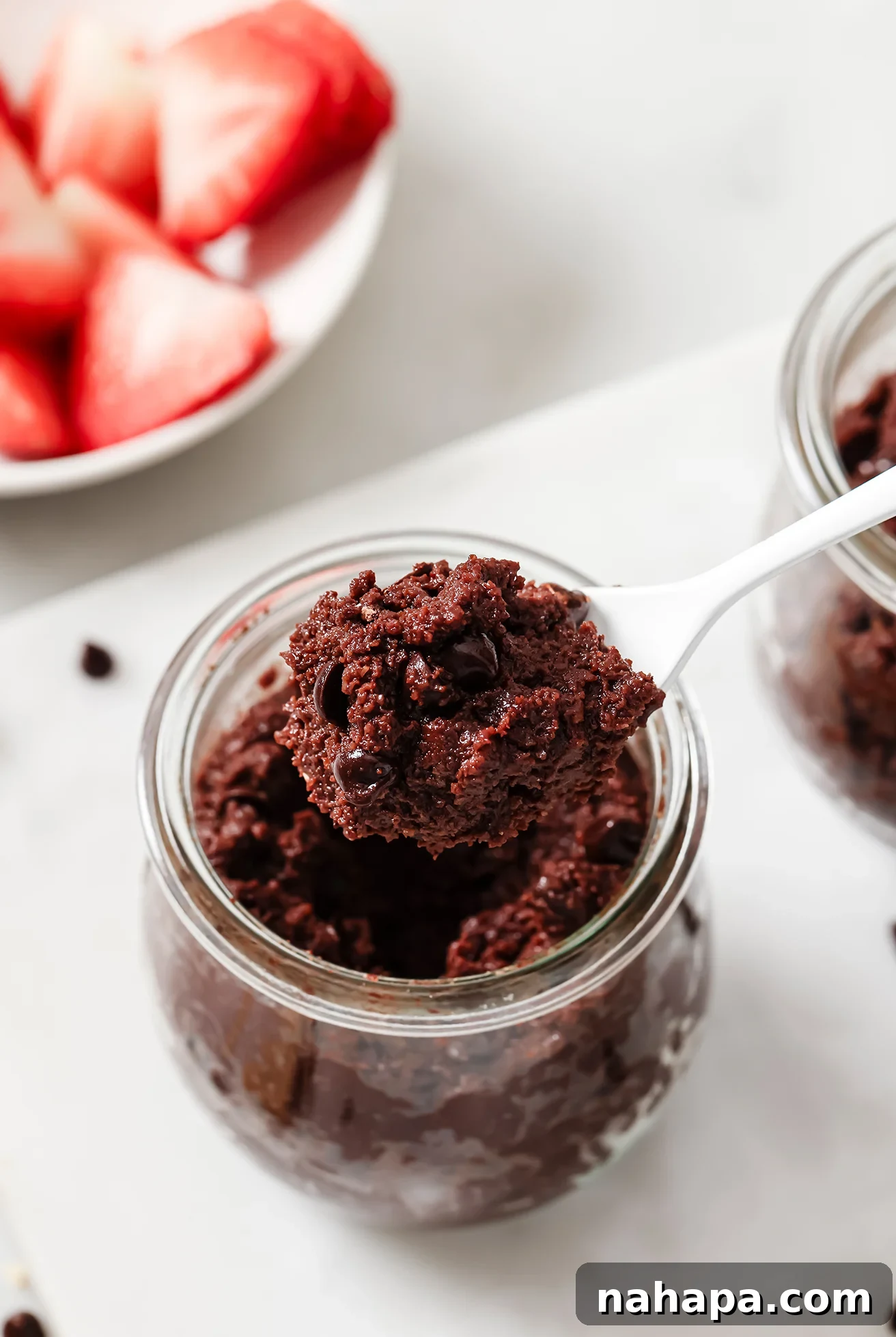 Gluten free brownie batter in a jar with a spoon.