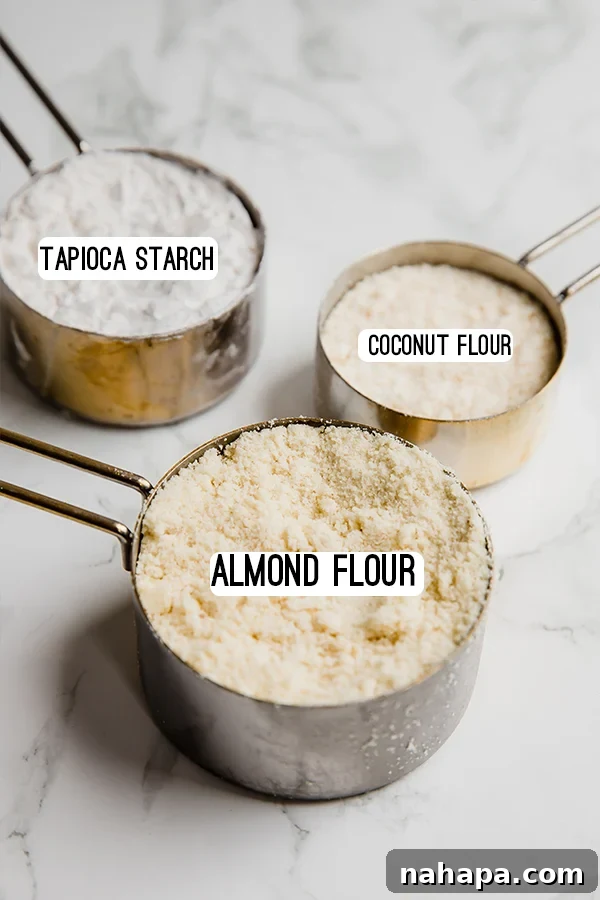 Two hands holding a wooden bowl of various grain-free flours