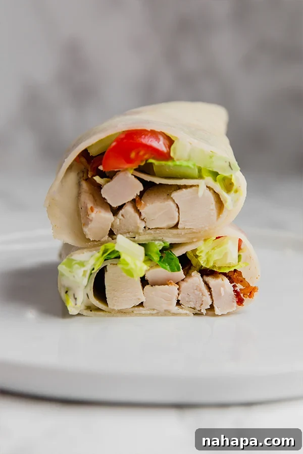 Close-up of a perfectly rolled and sliced Paleo Chicken Bacon Ranch Wrap, showing the vibrant ingredients inside.