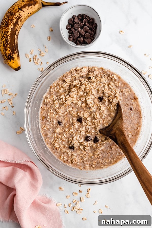 Oatmeal ingredients being mixed in a large bowl with a wooden spoon