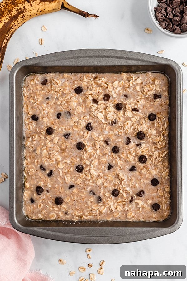 Baked oatmeal resting in a glass baking dish, sliced into portions and ready to be served