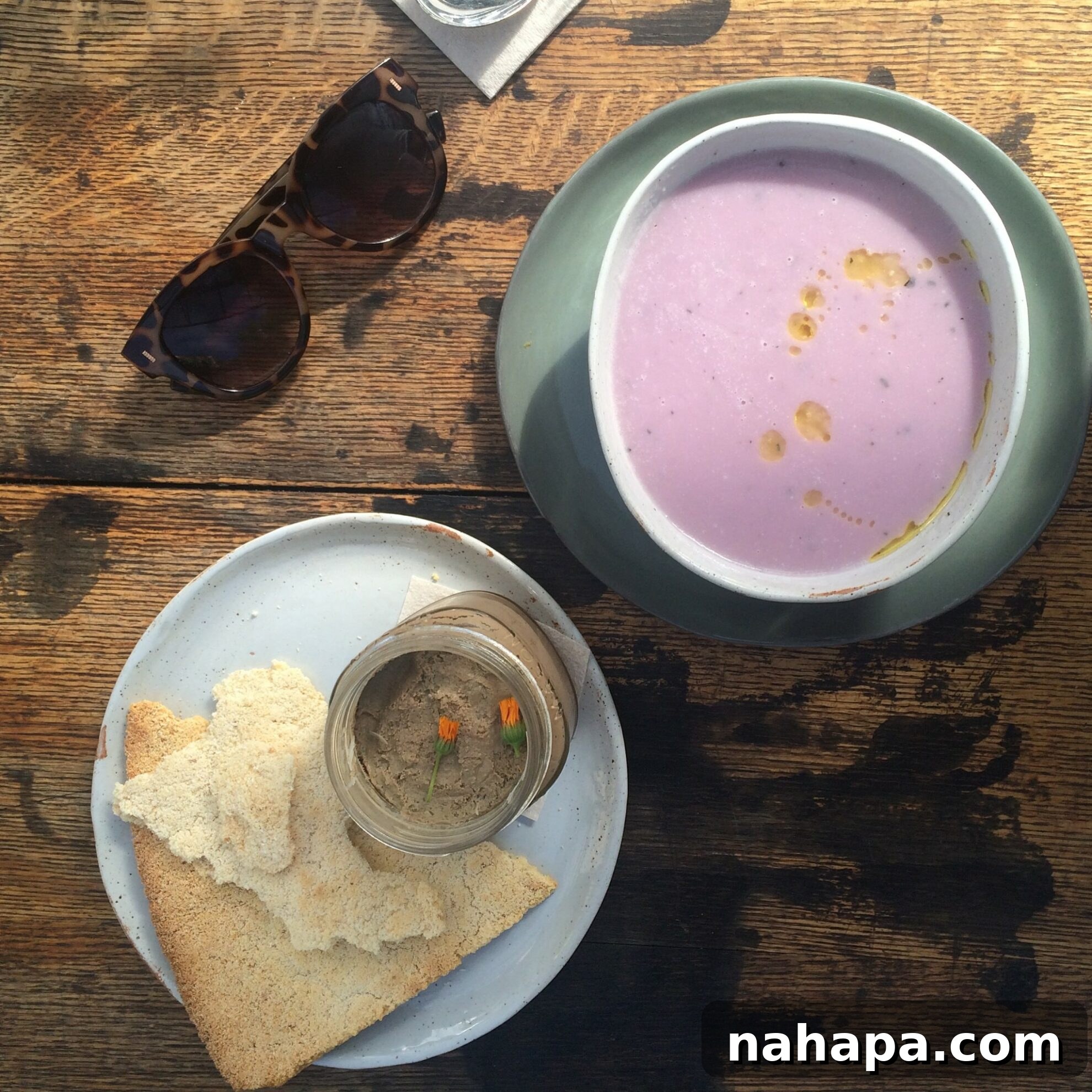 A close-up of a meticulously prepared AIP meal from Mission Heirloom, featuring a creamy cauliflower soup, rich chicken liver pate with apple sauce, and their famous crispy Yucan Crunch, a perfect example of gourmet AIP dining.
