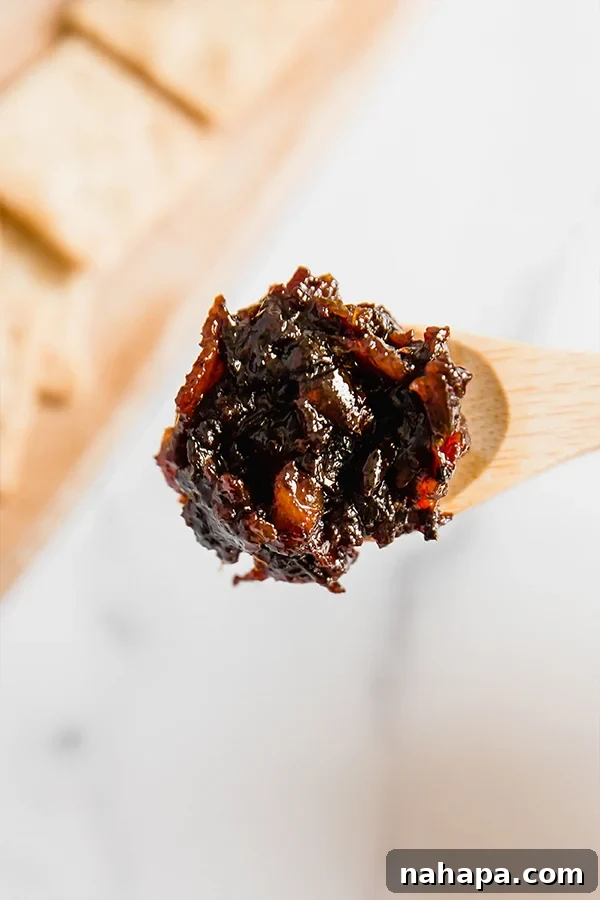 Caramelized Apple Bacon Delight 4 A spoon full of homemade Apple Bacon Jam, showing its rich texture and ingredients