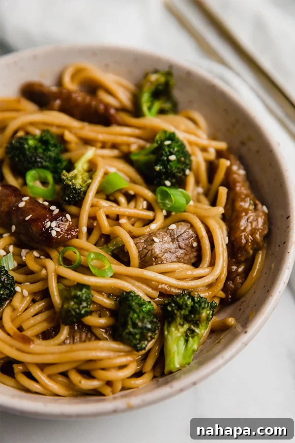 beef and broccoli lo mein in a bowl