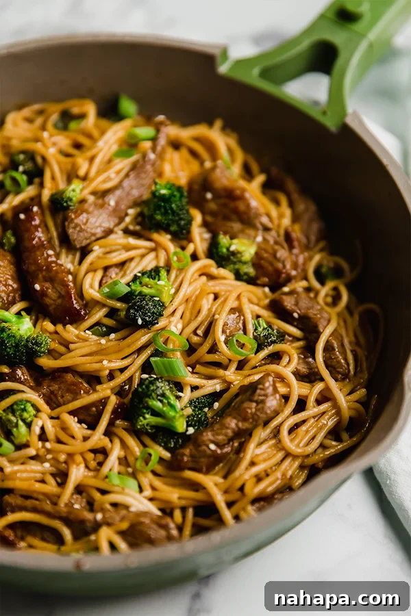 beef and broccoli lo mein in a pan