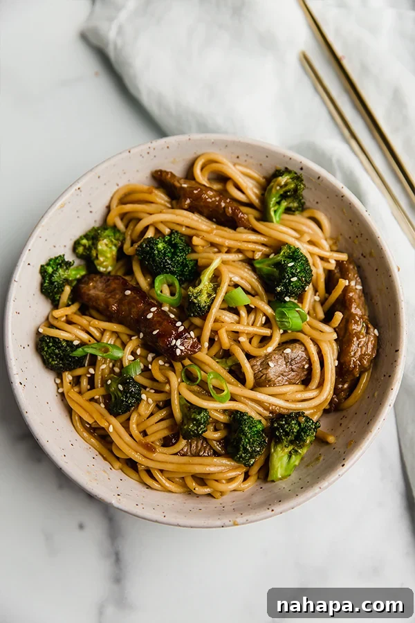 gluten-free beef and broccoli lo mein on plate with chop sticks