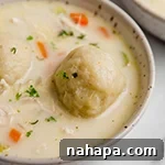 Nourishing Paleo AIP Chicken Cauliflower Dumplings 3 A top-down view of gluten-free chicken and cauliflower dumplings soup in a large serving bowl.