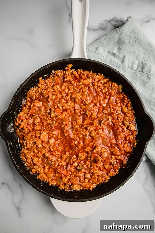 Wholesome Turkey Sloppy Joe Paleo AIP Whole30 4 Rich turkey sloppy joe mixture bubbling gently in a cast iron skillet, ready to be served.