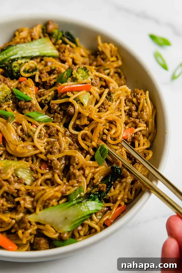 Delicious ground beef ramen stir fry served in a bowl with chopsticks, ready to eat
