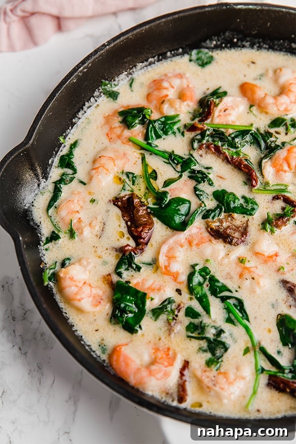 Sizzling Tuscan garlic shrimp served in a rustic cast iron skillet, showcasing its creamy sauce and fresh herbs