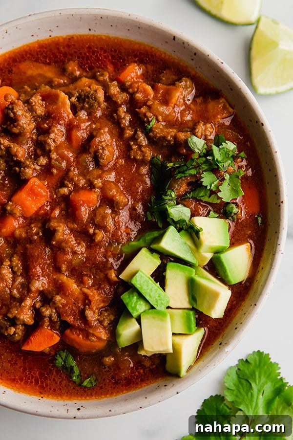 bacon & beef chili with avocado and cilantro, served in a rustic bowl