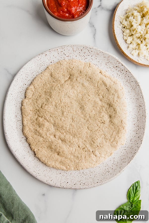 Baked pizza crust, golden brown and perfectly round, placed on a white plate