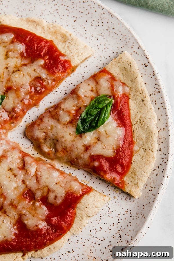 AIP Tigernut Flour Pizza Crust with various toppings, a slice on a plate