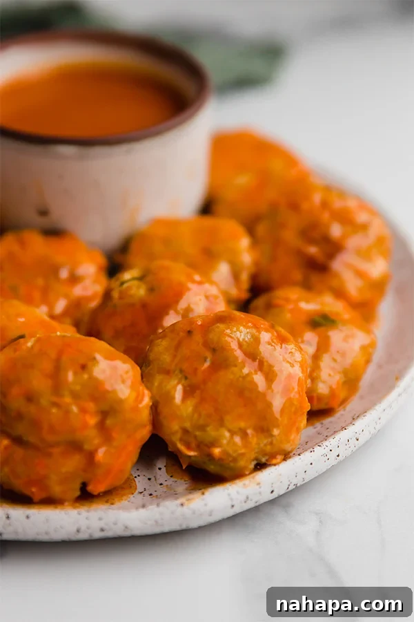 A trio of Buffalo Chicken Poppers artfully arranged, ready to be devoured with their spicy, tangy glaze.