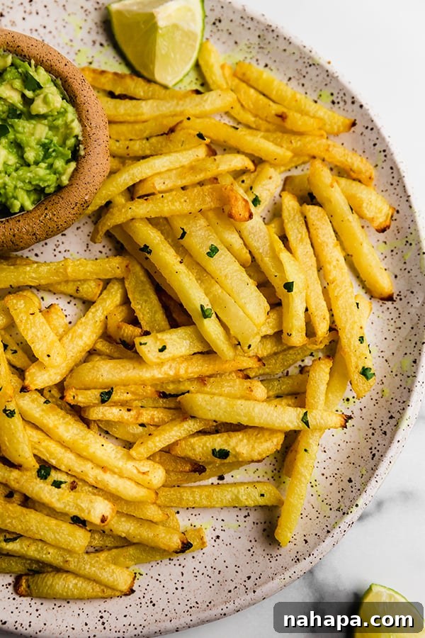 Three golden jicama fries arranged on a rustic wooden surface, highlighting their crisp texture and delicious seasoning.
