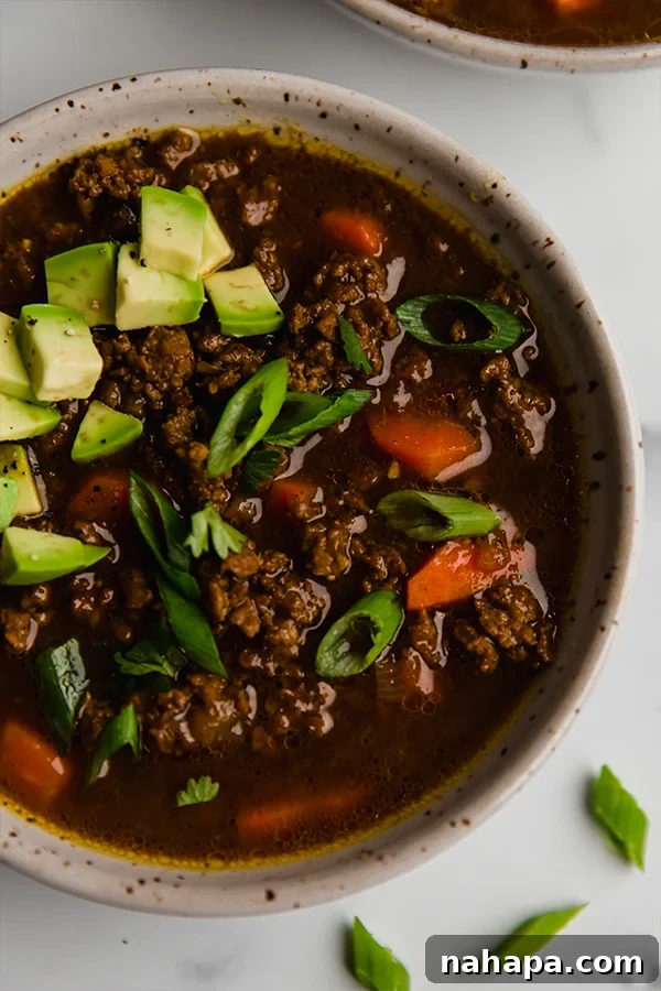 Asian Inspired Chili in a bowl, with fresh avocado and cilantro garnishes.