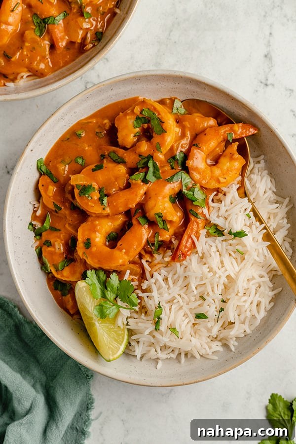 shrimp curry in a bowl with rice and lime